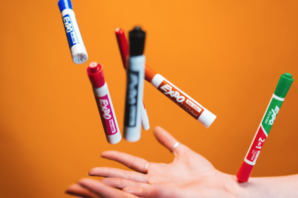 Video Production, A hand tosses seven dry-erase markers in to the air