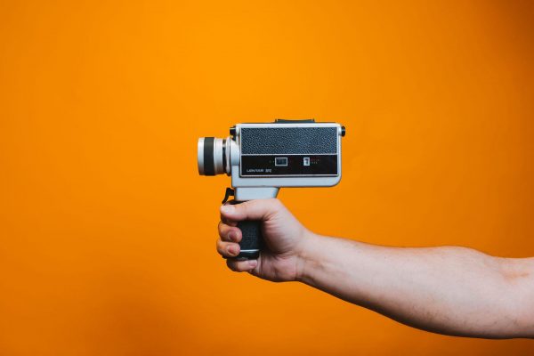 Video Marketing, a hand holds a vintage camera from the 80s